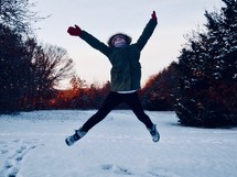 girl jumping in snow 
