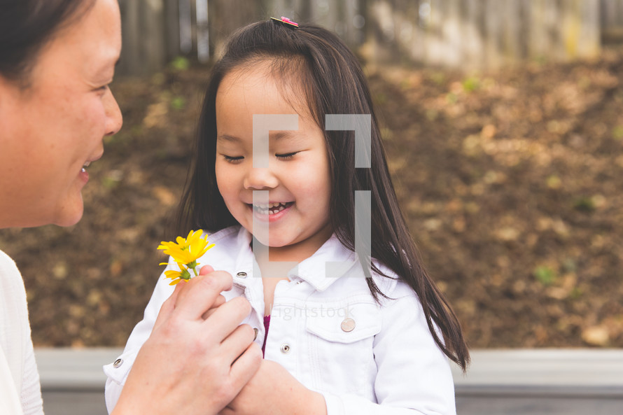 a girl giving her mother picked flowers 