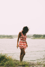 a woman walking along a shore 