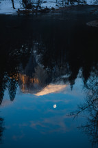 Reflection of snowy mountain in Yosemite with moon