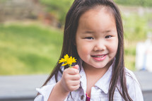 a girl child holding picked flowers 