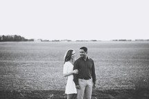 a couple embracing standing in a field 
