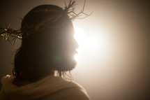 Jesus with a crown of thorns surrounded by glowing light 