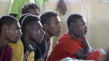 men listening to a worship service in Papua New Guinea 