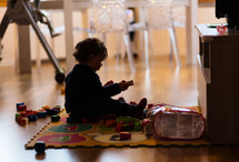 infant girl playing with toys at home 