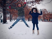 kids jumping in snow 