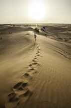 man running on sand dunes in a desert in Dubai