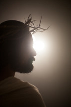 Jesus with a crown of thorns surrounded by a glowing light 