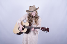 a teen girl playing a guitar 