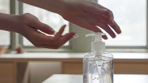 Corona pandemic - kids hands using hand sanitizer to prevent coronavirus spread