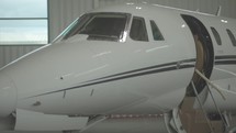 Nose and door of a private jet in a hanger