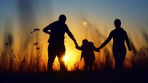 Silhouette happy family. Parents and little son fun at sunset. Silhouette family play at sunset. Teamwork child and parents fun in the park. Friendly family and kid dream concept.