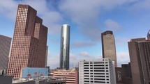 1500 Louisiana St (HOU150) building and other skyscraper buildings in downtown Houston, Texas city on a beautiful blue sky and cloudy day.