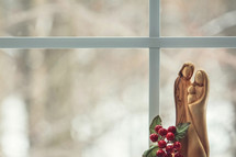 wooden nativity figurines in a window 