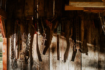 Antique farm tools hanging in barn.