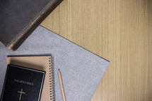 notebook, pencil, and Holy Bible on a desk 