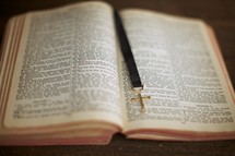 An open Bible with a cross bookmark down the middle