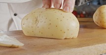 Slow motion of a chef slicing a potato using a sharp large knife