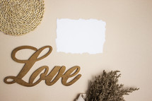 Blank white note with the word love and bouquet on tan background