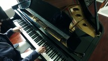 A man playing a grand piano 