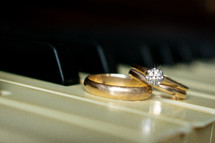 gold wedding rings on a piano  