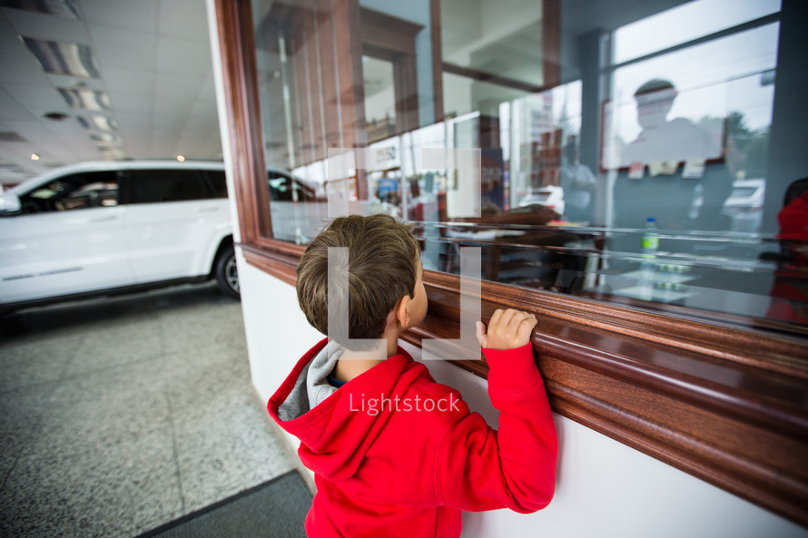 a child peeking into a window 