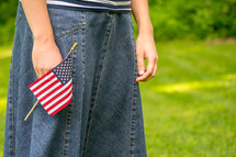 A girl holding a small American flag 