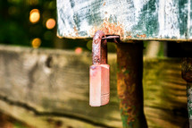 Old rusty padlock hanging from metal object