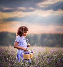 girl picking flowers in a field 