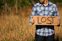Man holding "Lost" cardboard sign