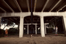 man and woman swinging under  highway 