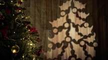Christmas tree adorned and lighted with shadow on the wall