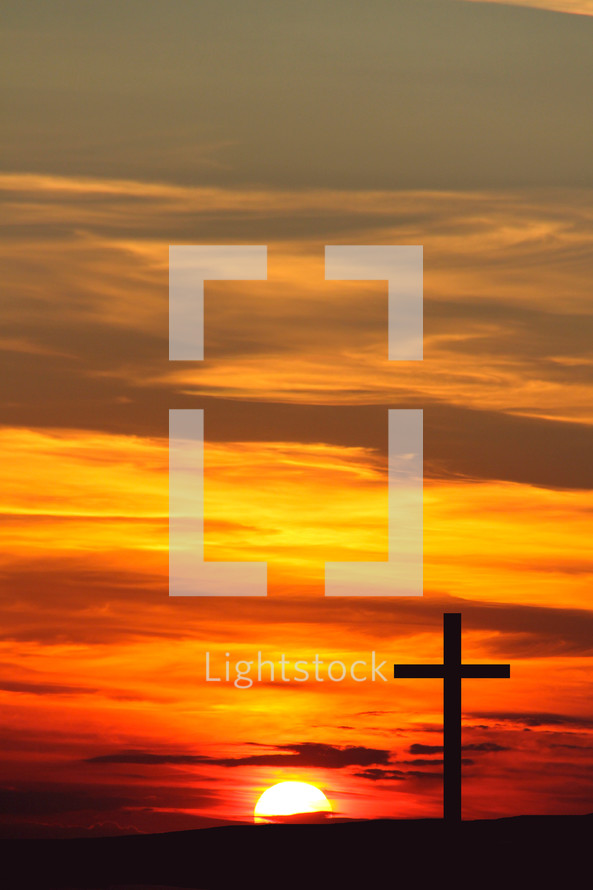 Sunrise behind a cross in silhouette 