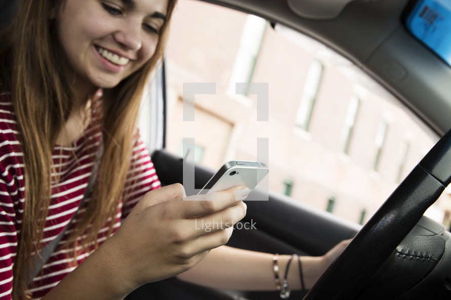 a teen girl texting while driving 