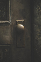 An old metal doorknob on an old door.