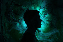 silhouette of a man standing in green swirling light 