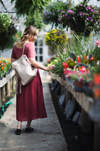 a young woman walking through a garden center 