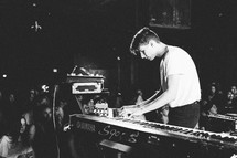 a man playing a digital keyboard on stage 