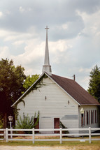 church and steeple with a white fence 