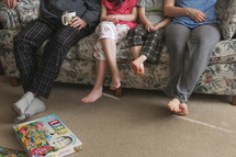 family sitting on a couch and board games on the floor 