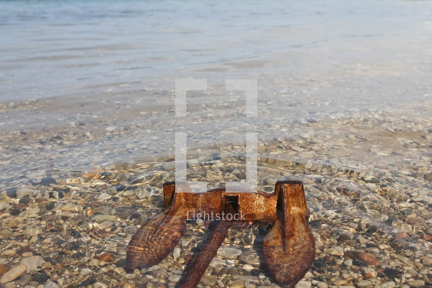 rusty anchor lying in the water