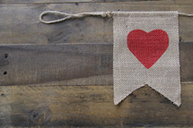 heart on a burlap banner against a wooden background 
