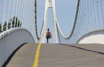 a man crossing a sloping bridge 