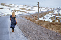woman walking along a rural road alone 