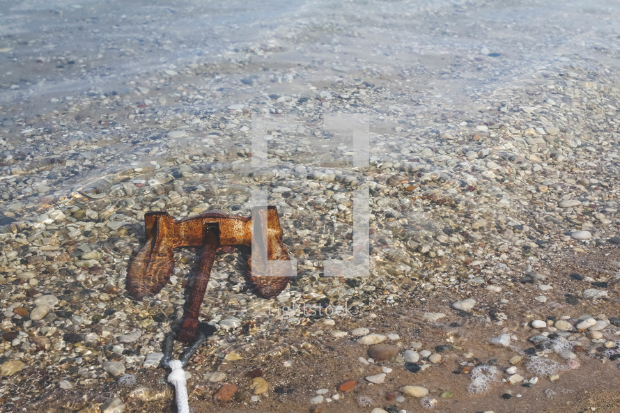 rusty anchor lying in the water
