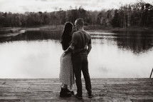 a couple standing in front of a pond 
