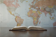 world map and open Bible on a desk 