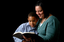 A mother and son reading the Bible.