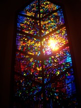 Stained glass window to Heaven with blue, red, yellow, purple colors in a small church chapel.