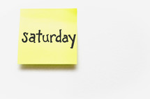 A yellow sticky note with "saturday" written in black ink.